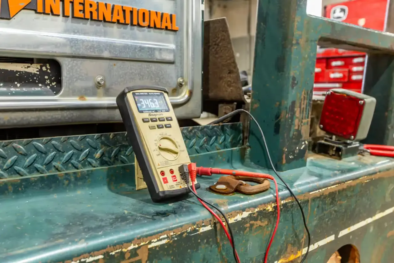 Multimeter testing a truck electrical system