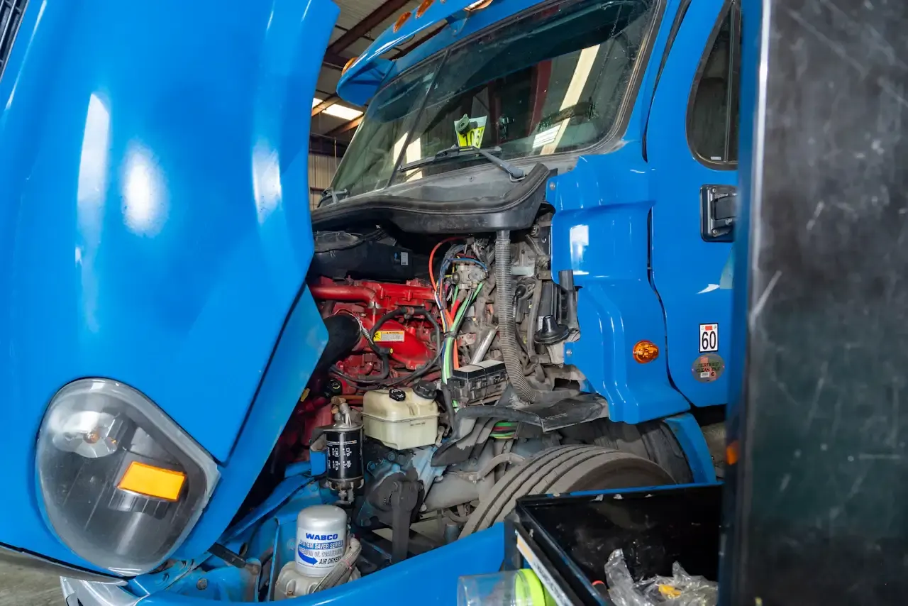 Blue semi truck with the engine opened up for a rebuild
