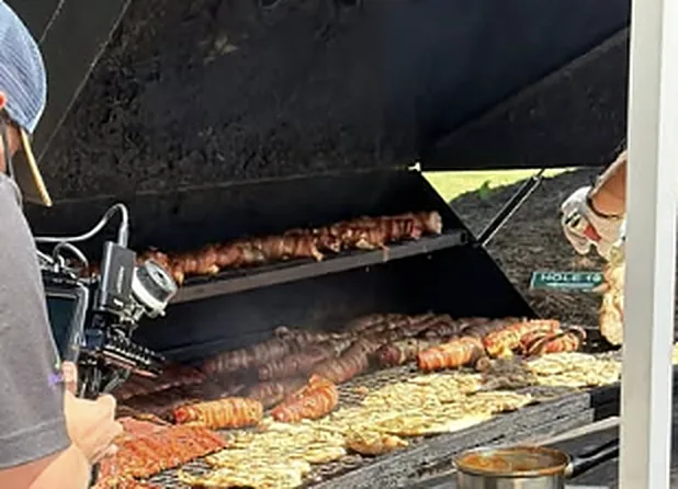 Food cooking on a large grill at a community event