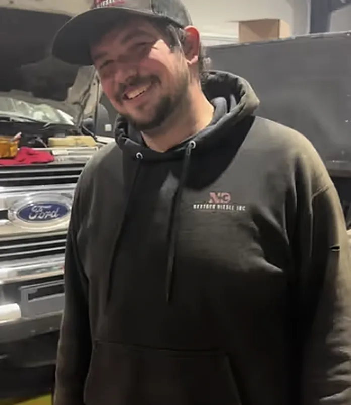 A smiling NextGen Diesel team member in the shop