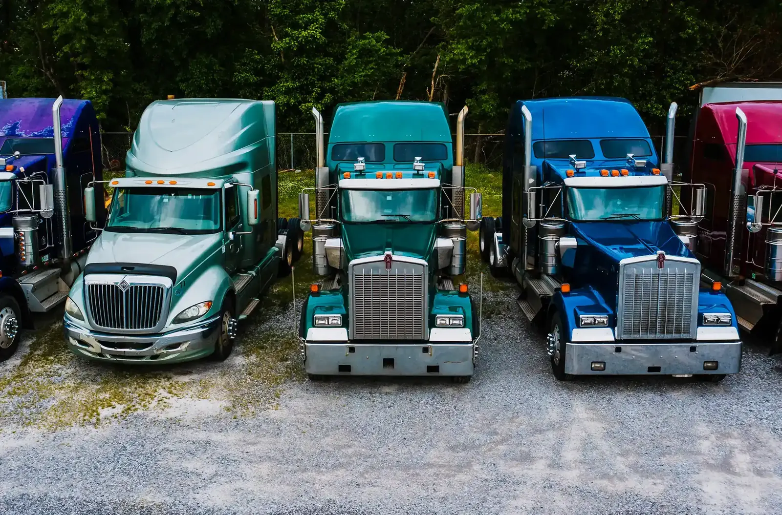 A row of semi trucks parked in a fleet yard