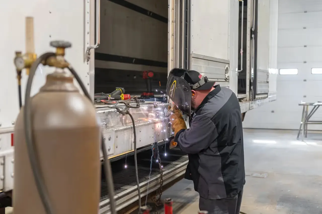 Welder fabricating a part on a truck chassis